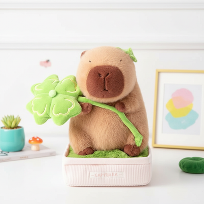 Stuffed animal toy resembling a capybara holding a flower, placed on a white surface with a light background.