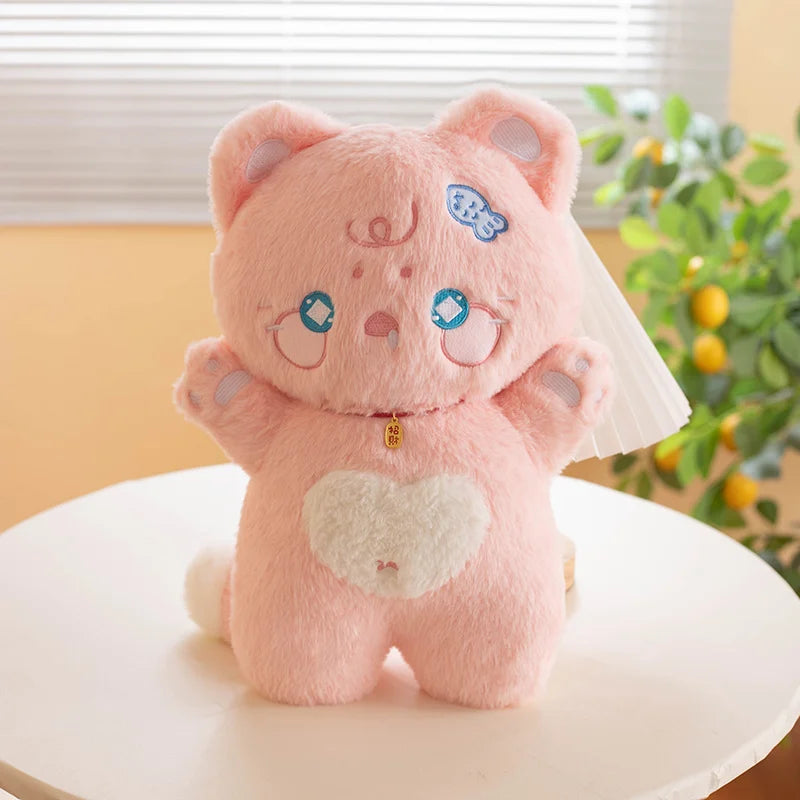 Pink cat plush toy with a heart on a white surface