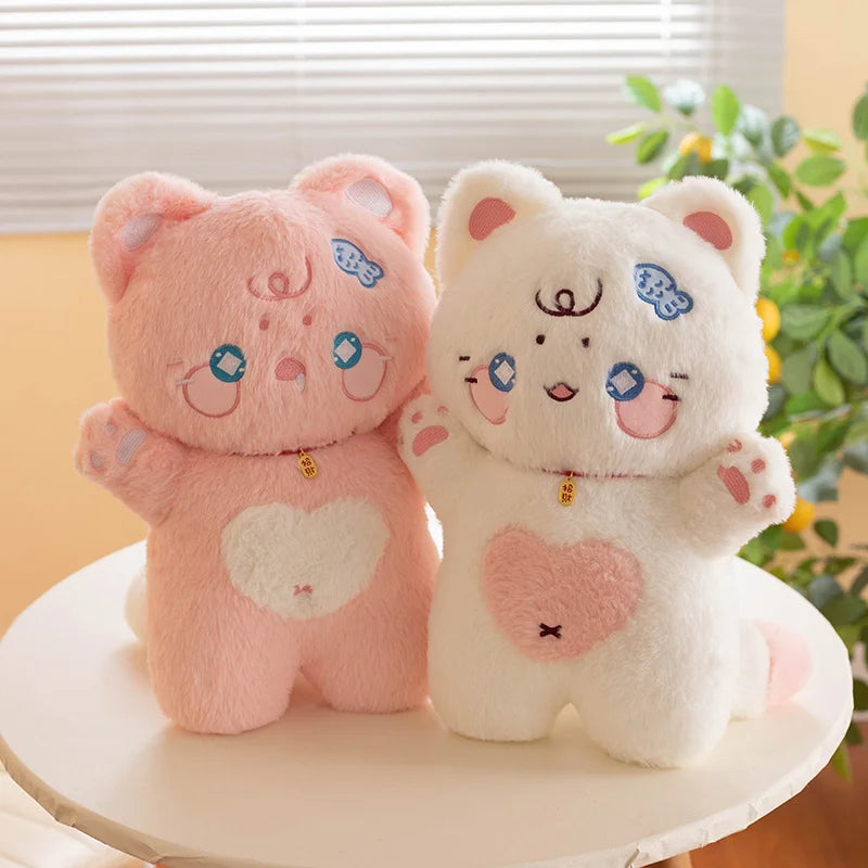 Two kawaii cat plush toys, one pink and one white, with cartoon faces on a white surface.