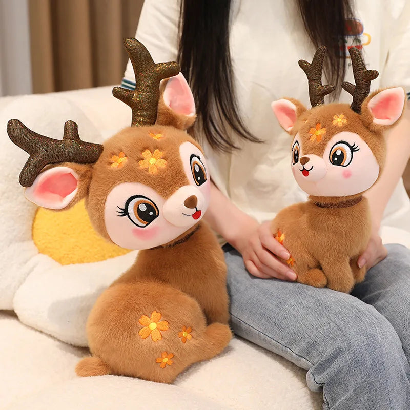 Two plush deer toys held by a person on a light-colored surface.