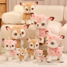 Set of plush deer toys in various sizes on a light-colored couch.