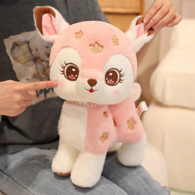 Cute plush toy resembling a deer with pink and white colors, held by a person.