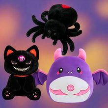 Three Halloween plush toys: a black spider, a black cat, and a purple bat with pink accents on a white background.