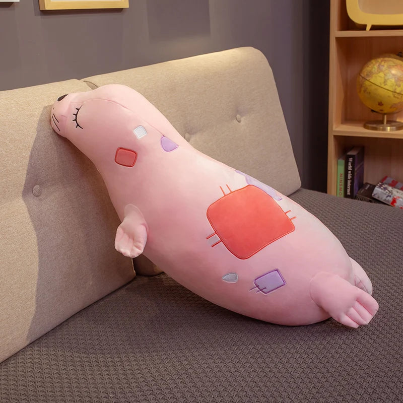 Pink plush toy resembling Kawaii Sea Lion Plushie character on a couch