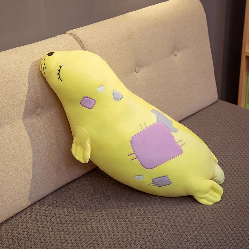 Yellow plush toy resembling a Kawaii Sea Lion Plushie on a brown couch.