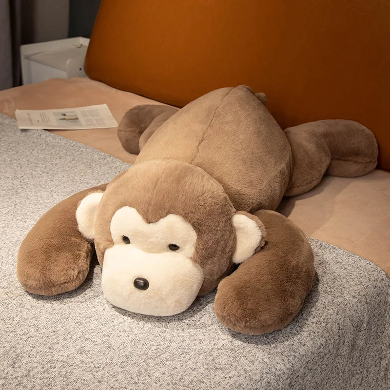 Brown monkey plush toy lying on a bed