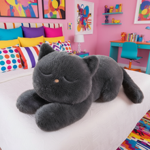 Giant gray cat plushie laying on a bed in a colorful bedroom setting