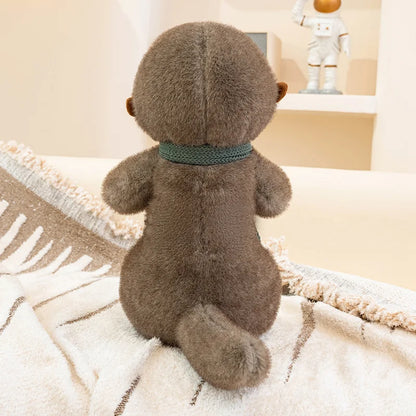 Brown sea otter with a green ribbon sitting on a textured surface.