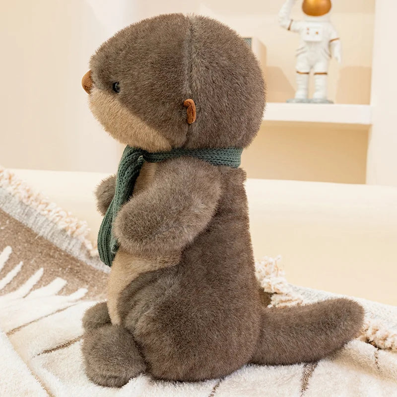 Plush otter toy wearing a green scarf on a soft surface