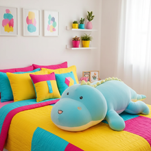Colorful bedding set with a dinosaur-shaped pillow on a bed in a bright room.