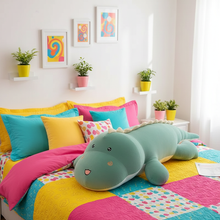 Colorful bedroom with a large green dinosaur plush toy on a bed.