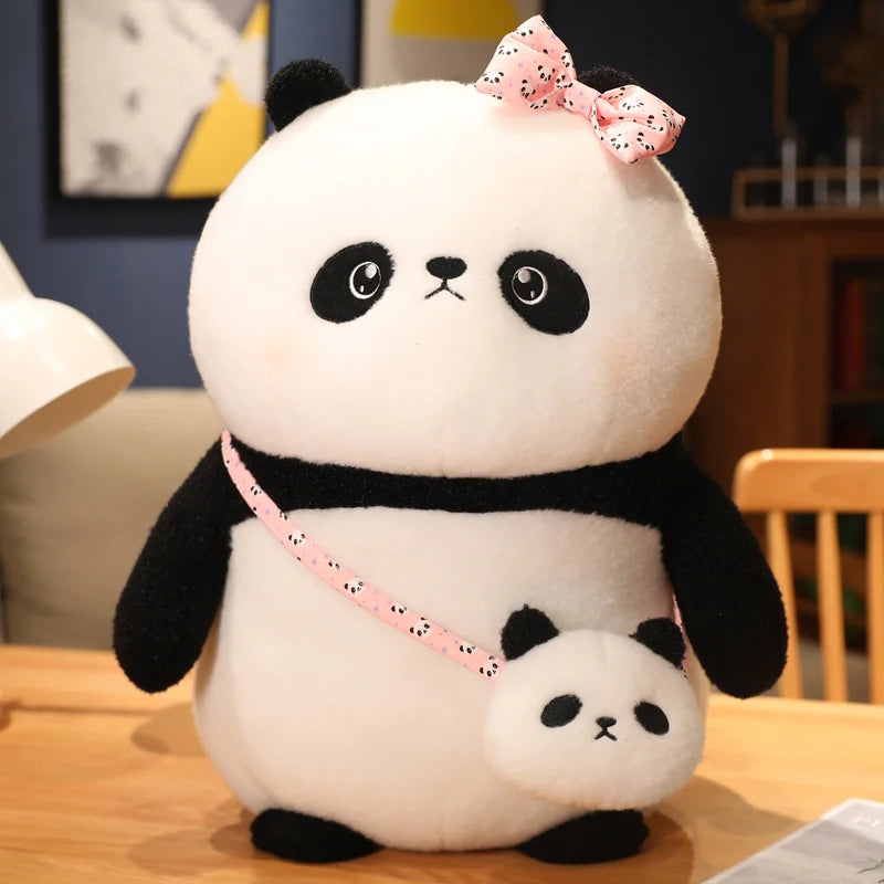 Plush panda toy with a smaller plush toy on a wooden table.