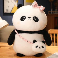 Plush panda toy with a smaller plush toy on a wooden table.