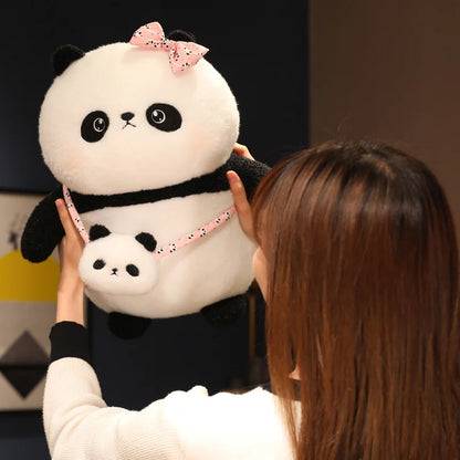 Person holding a large plush panda toy with a smaller panda on a leash.