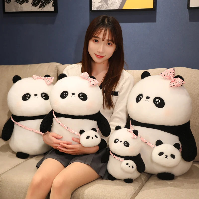 Woman sitting on a couch with large panda plush toys wearing pink bows.