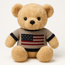 Teddy bear wearing a sweater with an American flag design on a white background