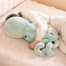 Person holding a large plush octopus toy on a soft surface