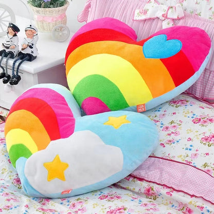 Colorful heart-shaped pillow with rainbow design on a floral bedspread.