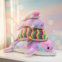 Stack of colorful plush dolphins on a light surface with a soft, blurred background