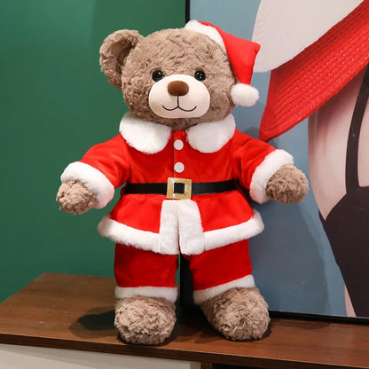 Plush teddy bear wearing a Santa Claus outfit on a wooden surface with a colorful background.
