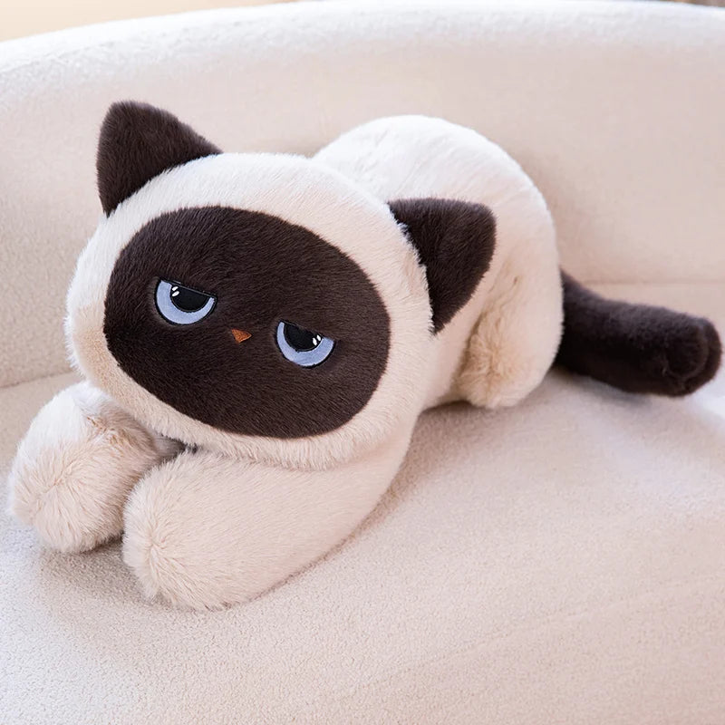 Plush toy resembling a Siamese cat on a beige couch