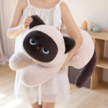 Person holding a large plush cat toy in a home setting