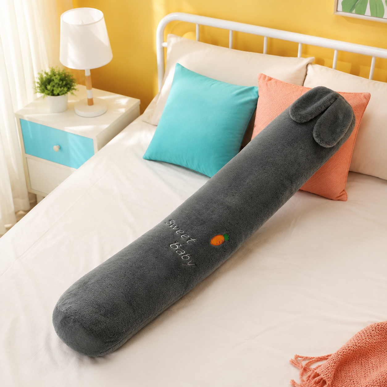 Charcoal gray dog long plushie body pillow with floppy ears on a colorful bed