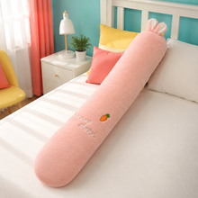 Peach pink rabbit long animal plushie body pillow on a colorful bed
