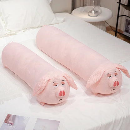 Two pink pig-shaped plushie body pillows on a bed