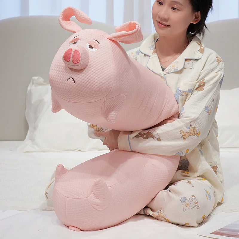 Person holding a large pink pig-shaped pillow on a bed