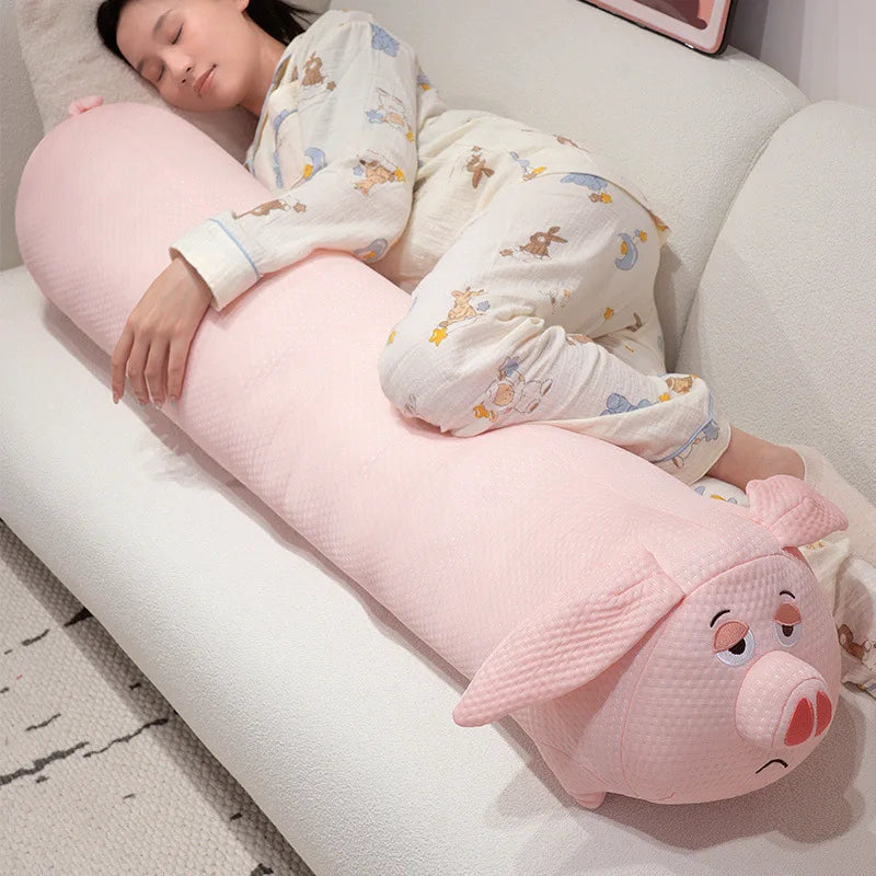 Person lying on a pink pig-shaped body pillow on a couch