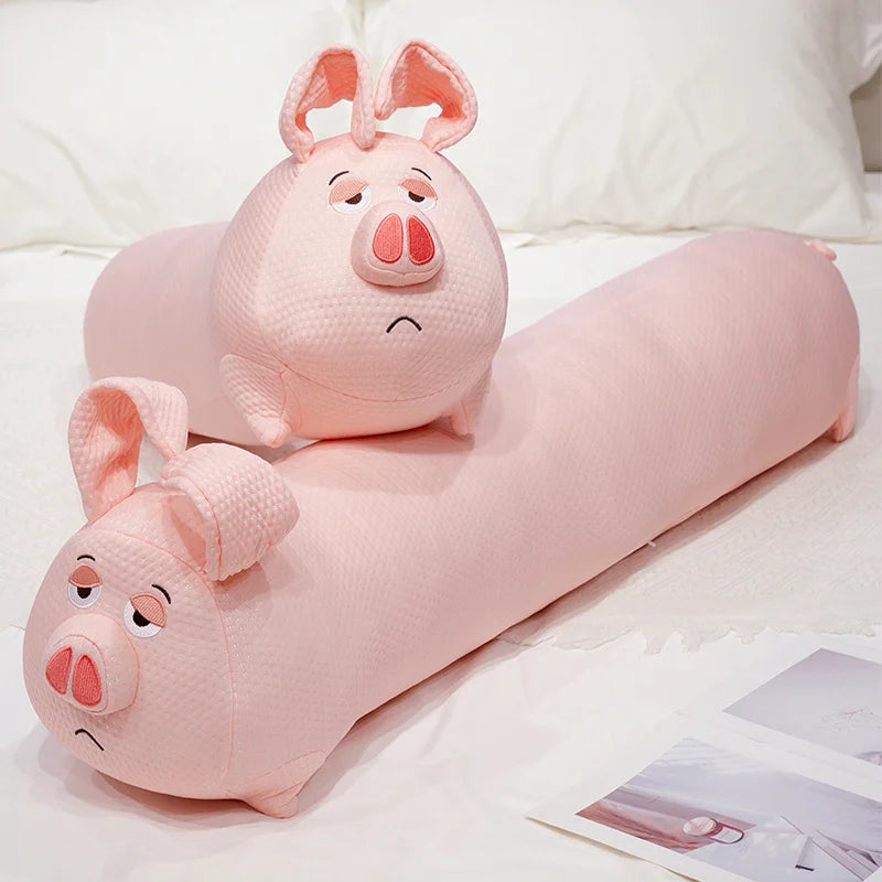 Two pink pig-shaped body pillows on a white surface.