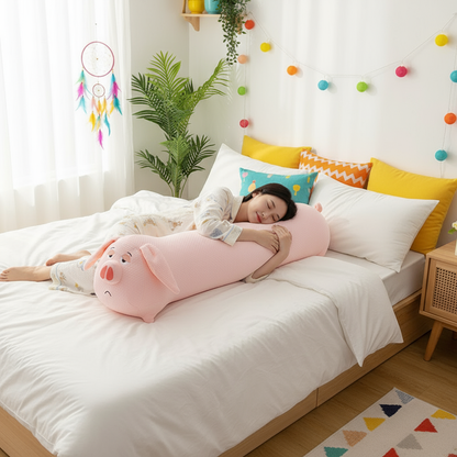 Person lying on a bed with a large pink pig-shaped pillow, surrounded by colorful pillows and decor.