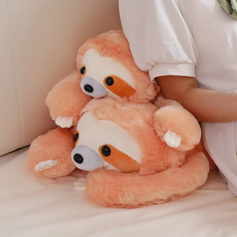 Two stacked plush toys resembling sloths on a light-colored surface.