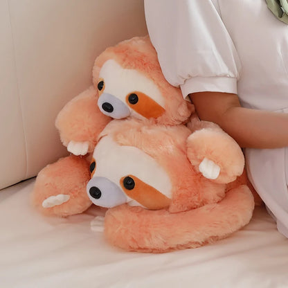 Two stacked plush toys resembling sloths on a light-colored surface.