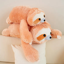 Two plush sloths sitting on a light-colored surface with a neutral background