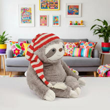 Plush sloth toy wearing a red and white striped hat in a colorful living room.