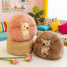 Two plush hedgehog toys on a bed with a colorful background