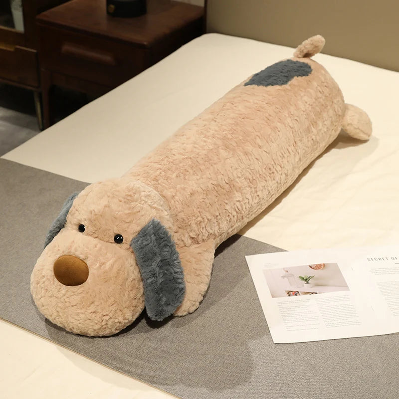 Dog-shaped kawaii plushie body pillow on a bed with a magazine underneath
