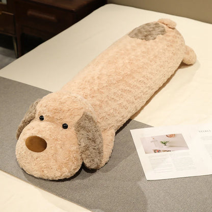 Long dog-shaped plushie body pillow on a bed with a magazine underneath