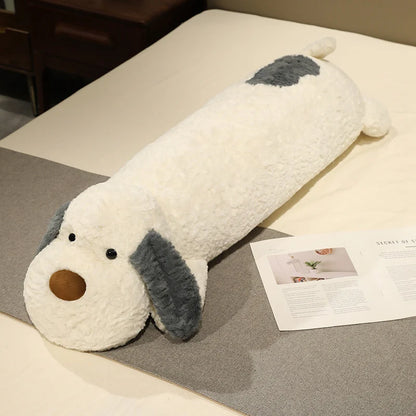 Dog-shaped plushie body pillow on a bed next to a magazine