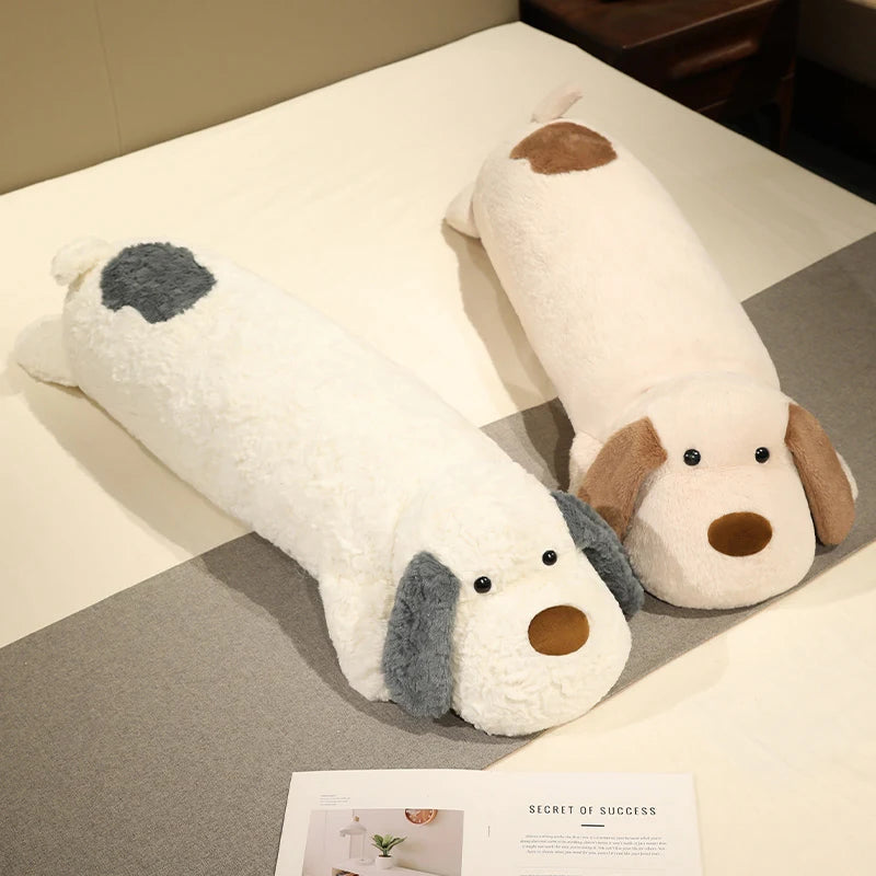 Dog-shaped body pillow plushie on a bed with a magazine underneath