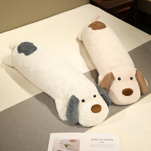 Dog-shaped body pillow plushie on a bed with a magazine underneath