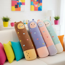Colorful cartoon-style cylindrical plushie pillows on a couch with a bright, indoor setting.