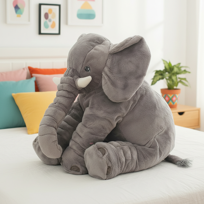 Plush elephant toy on a bed with colorful pillows and a plant in the background