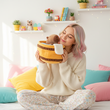 Woman holding a plush bathtub with a capybara surrounded by colorful pillows and decor items.