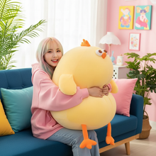 Person holding a large yellow plush duck toy in a colorful living room.