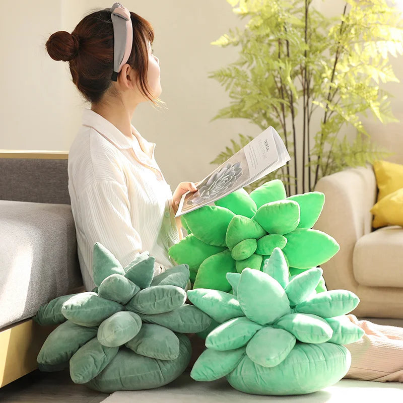 Woman sitting on a couch with succulent-shaped green pillows and a plant in the background.