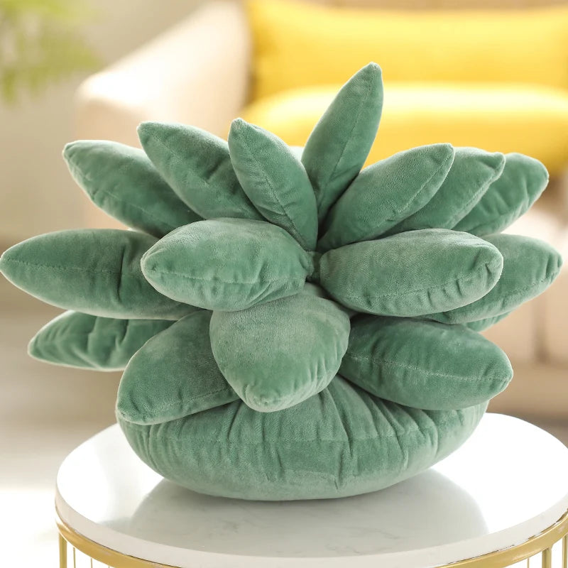 Green succulent-shaped plushie pillow on a round table with a blurred background