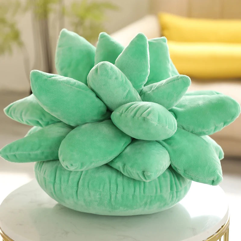 Green succulent-shaped plushie pillow on a table with a blurred background